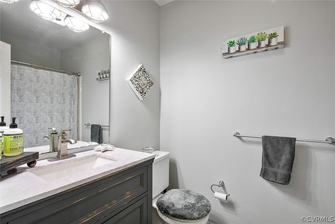 12808 Middlebrook Road Chester, VA 23831 - Photo 31 of 35 a bathroom with a granite countertop sink a toilet and a mirror