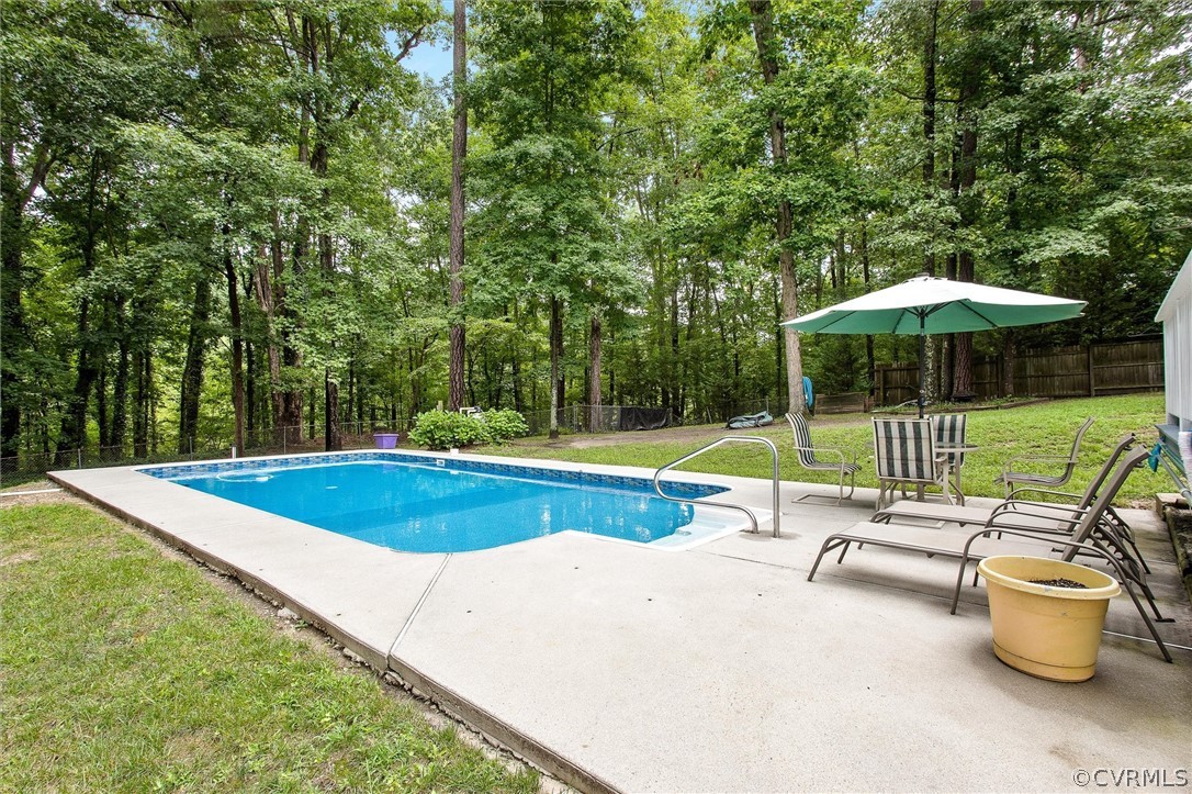 12808 Middlebrook Road Chester, VA 23831 - Photo 34 of 35 a view of a swimming pool with lawn chairs under an umbrella