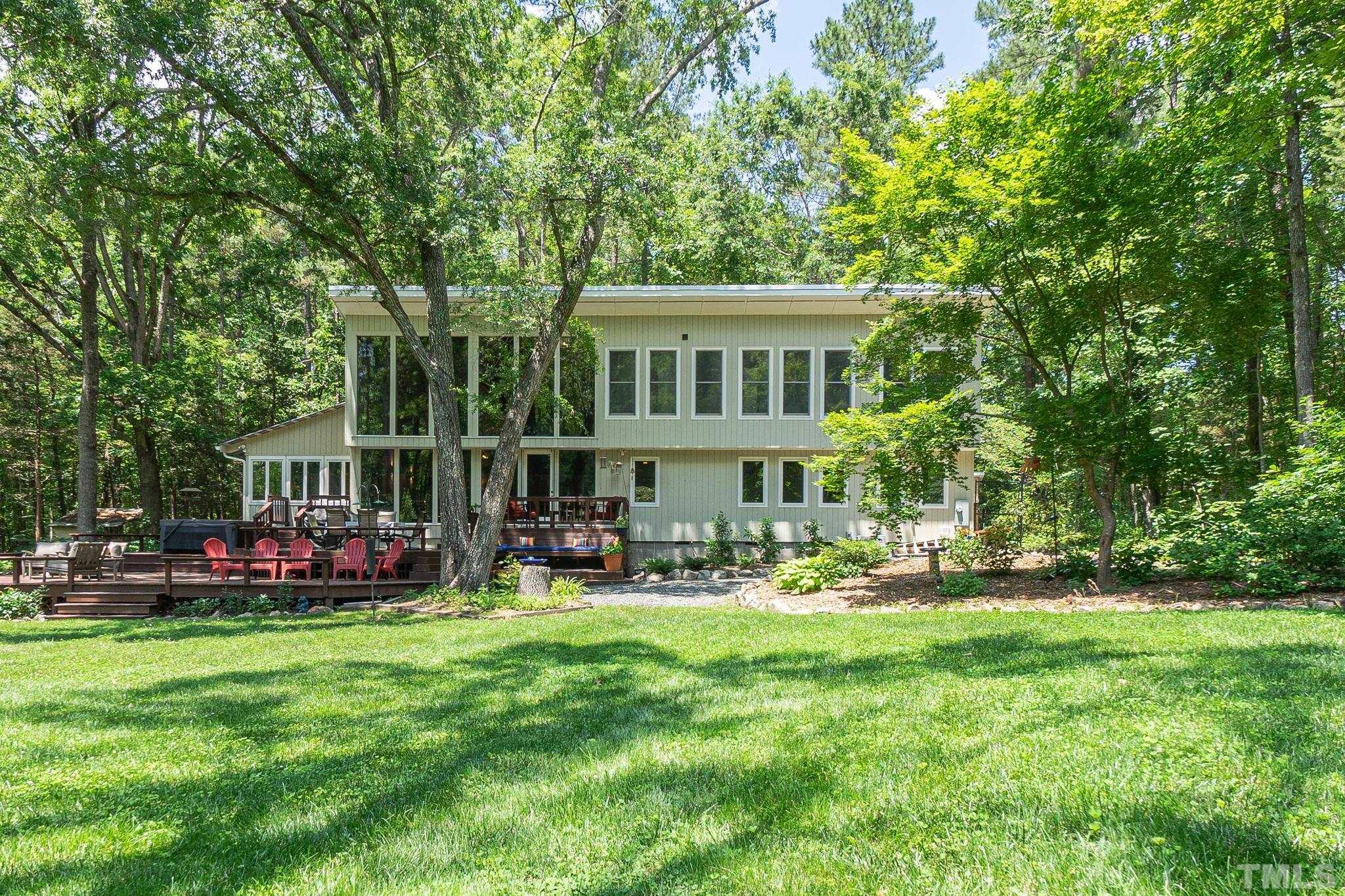 a front view of a house with a garden and trees