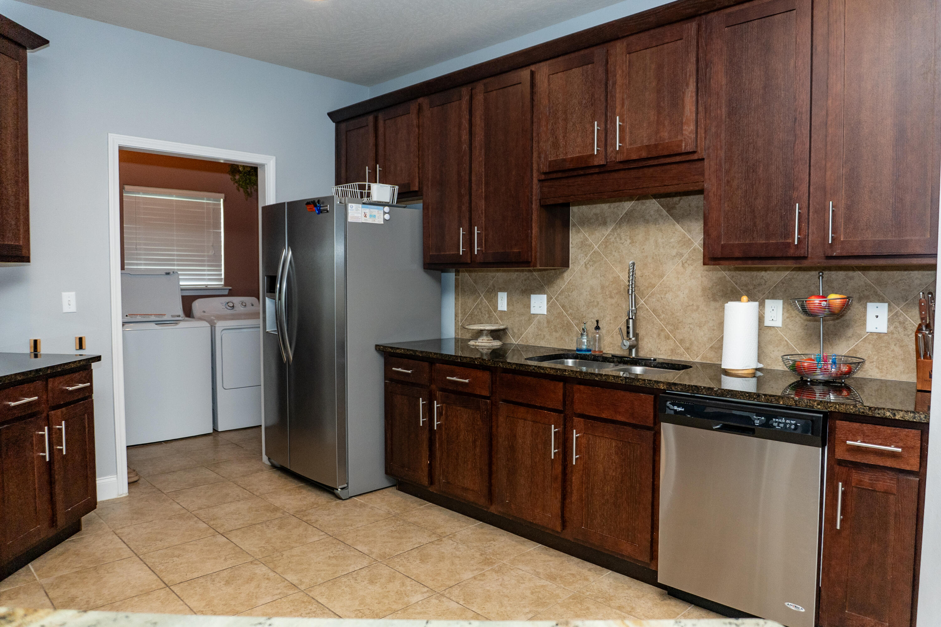 4517 Beth Circle Crestview, FL 32539 - Photo 12 of 45 a kitchen with granite countertop wood cabinets a refrigerator and a sink