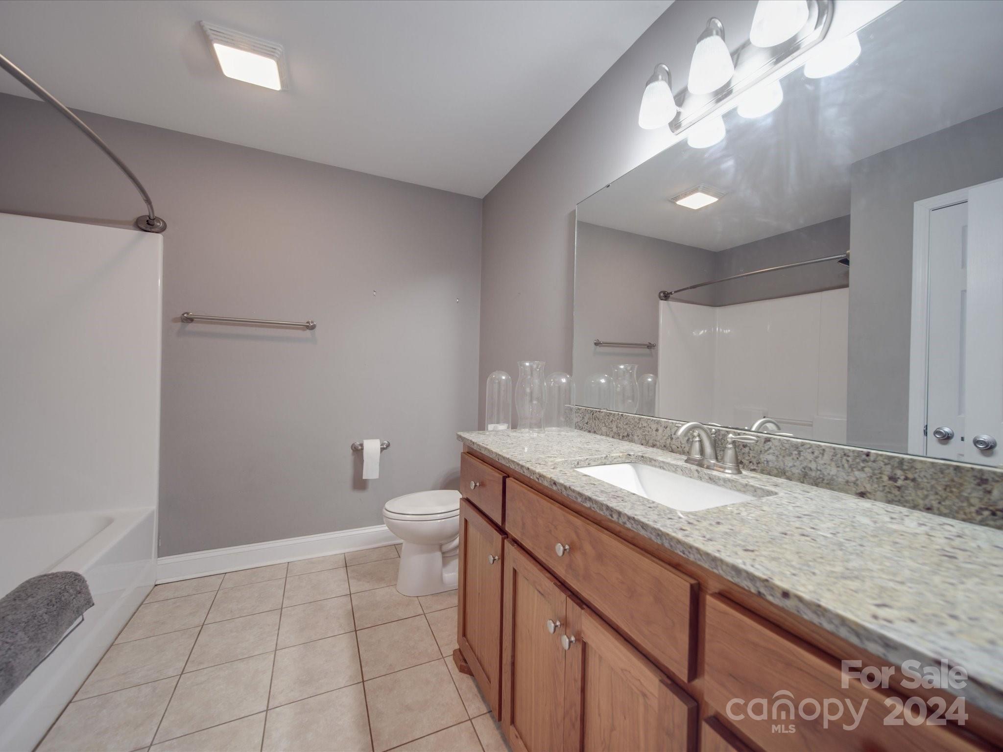 345 Springlake Road York, SC 29745 - Photo 17 of 17 a bathroom with a granite countertop sink a toilet and a mirror