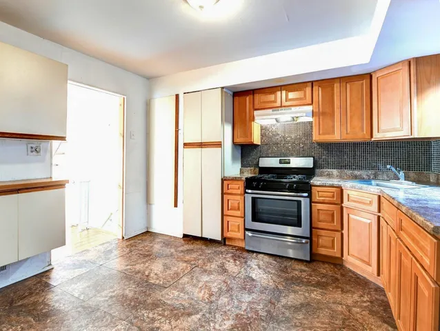 a kitchen with a stove a sink and a refrigerator