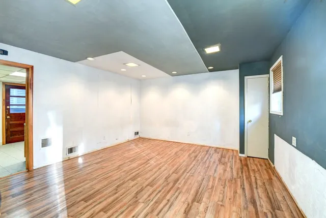 a view of an empty room with wooden floor
