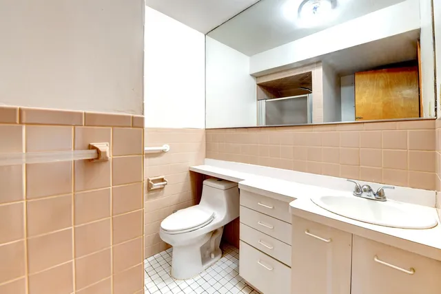 a bathroom with a toilet sink and mirror