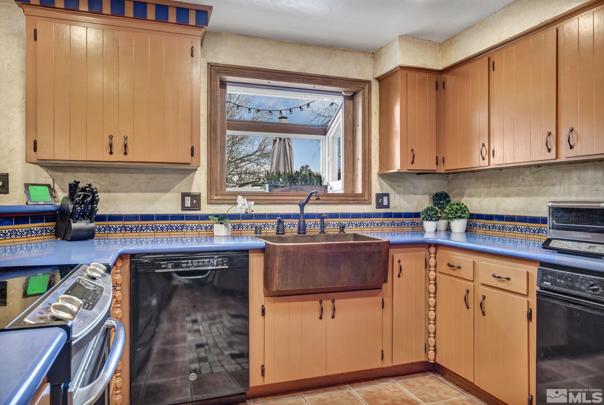 14230 Riata Circle Reno, NV 89521 - Photo 6 of 40 a kitchen with stainless steel appliances granite countertop a sink stove and cabinets