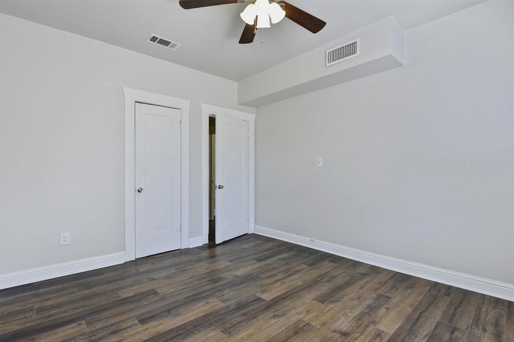 1115 South Rusk Avenue Denison, TX 75020 - Photo 19 of 21 an empty room with a ceiling fan and wooden floor