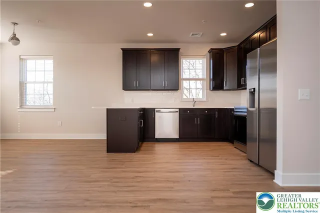 a large kitchen with wooden cabinets and a wooden floor