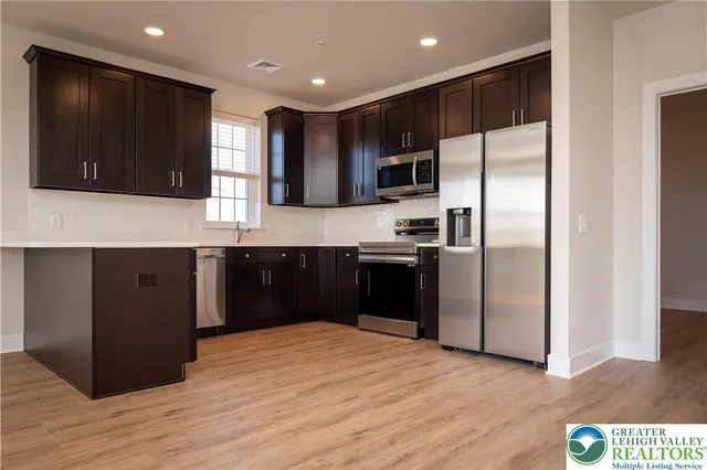 a kitchen with stainless steel appliances granite countertop a refrigerator and a sink