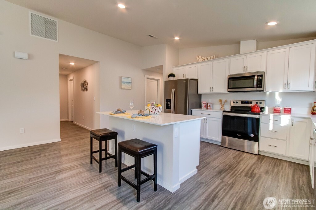 27 Jonagold Lane Manson, WA 98831 - Photo 8 of 32 a kitchen with stainless steel appliances kitchen island granite countertop a stove a sink and a microwave