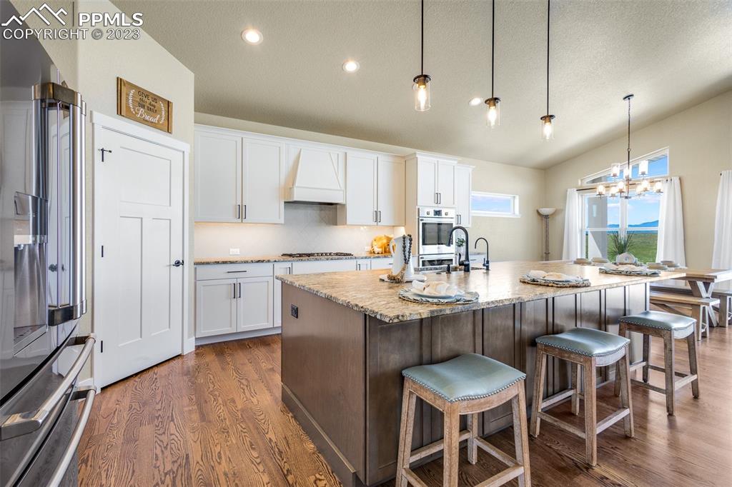 2960 Longhorn Rdg View Peyton, CO 80831 - Photo 11 of 49 a kitchen with stainless steel appliances granite countertop a sink a stove a refrigerator dining table and chairs