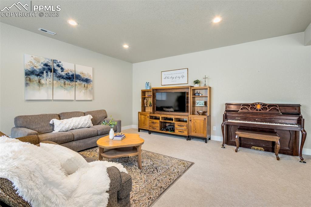 2960 Longhorn Rdg View Peyton, CO 80831 - Photo 26 of 49 a living room with furniture a flat screen tv and a stove