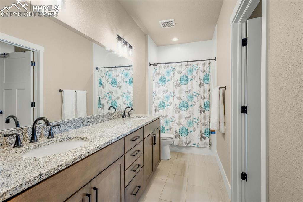 2960 Longhorn Rdg View Peyton, CO 80831 - Photo 29 of 49 a bathroom with a granite countertop double vanity sink mirror double and shower