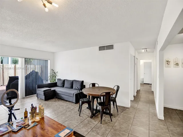 a living room with furniture a rug and white walls