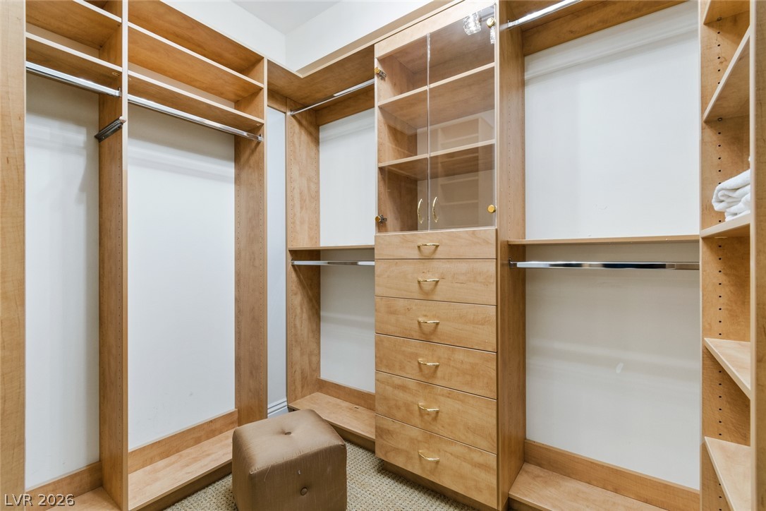 2857 Paradise Road, Unit 602 Las Vegas, NV 89109 - Photo 20 of 33 Custom built-in shelving and glass-front cabinetry optimize storage in this walk-in closet.