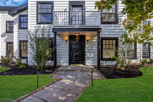 a view of a house with brick walls and a yard with a large tree