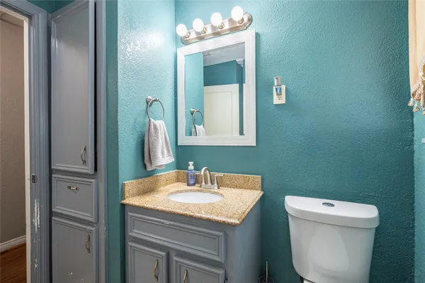 a bathroom with a sink a toilet and mirror