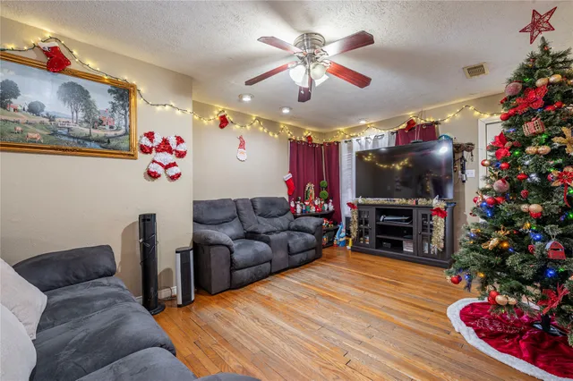 a living room with furniture a chandelier and a flat screen tv