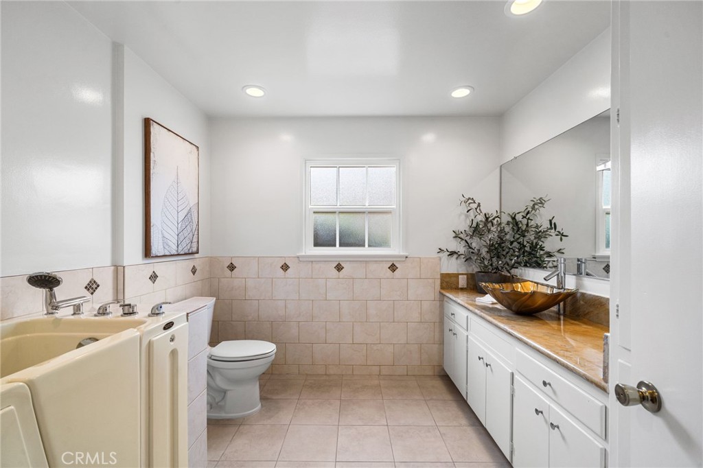 1107 Sharon Road Santa Ana, CA 92706 - Photo 26 of 37 a bathroom with a granite countertop sink a large mirror and a bathtub