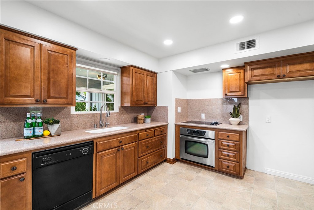 1107 Sharon Road Santa Ana, CA 92706 - Photo 30 of 37 a kitchen with stainless steel appliances a stove sink and cabinets