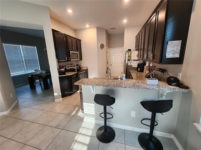 a kitchen with granite countertop a counter space cabinets and stainless steel appliances