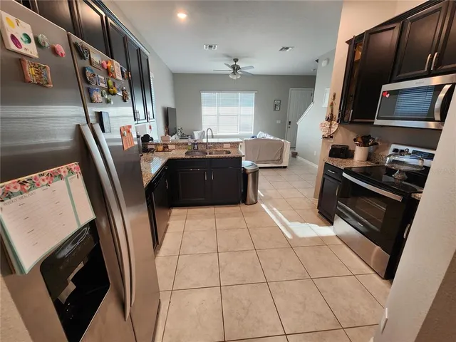 a kitchen with stainless steel appliances a stove a microwave a sink a refrigerator and cabinets