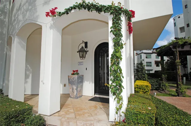 a front view of a building with lot of trees