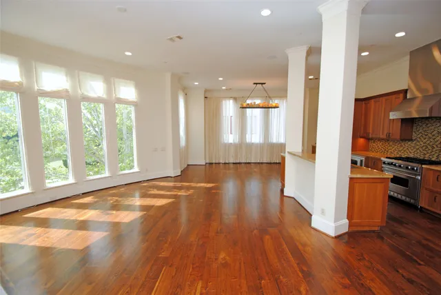 a kitchen with granite countertop a stove a sink dishwasher and a microwave oven with wooden floor