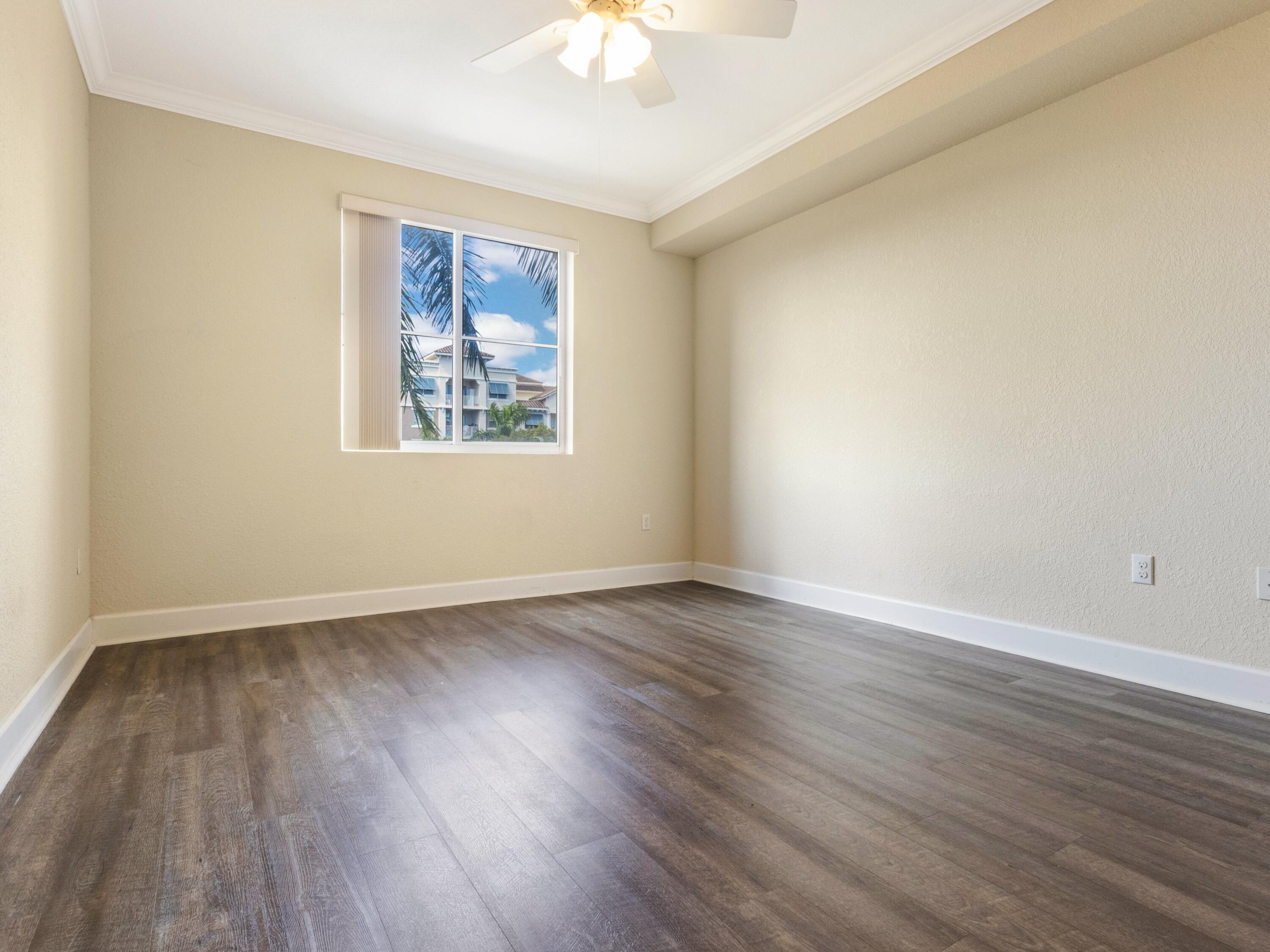 1690 Renaissance Commons Boulevard, Unit 1412 Boynton Beach, FL 33426 - Photo 13 of 49 a view of an empty room with wooden floor and a window
