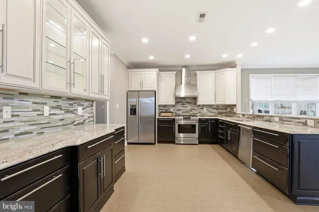 a kitchen with stainless steel appliances granite countertop a stove a sink and a refrigerator