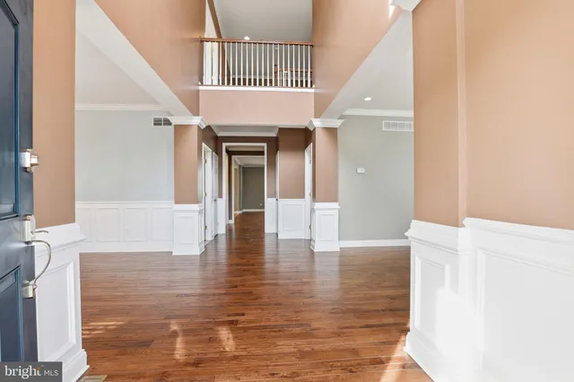 a view of a big room with wooden floor and windows