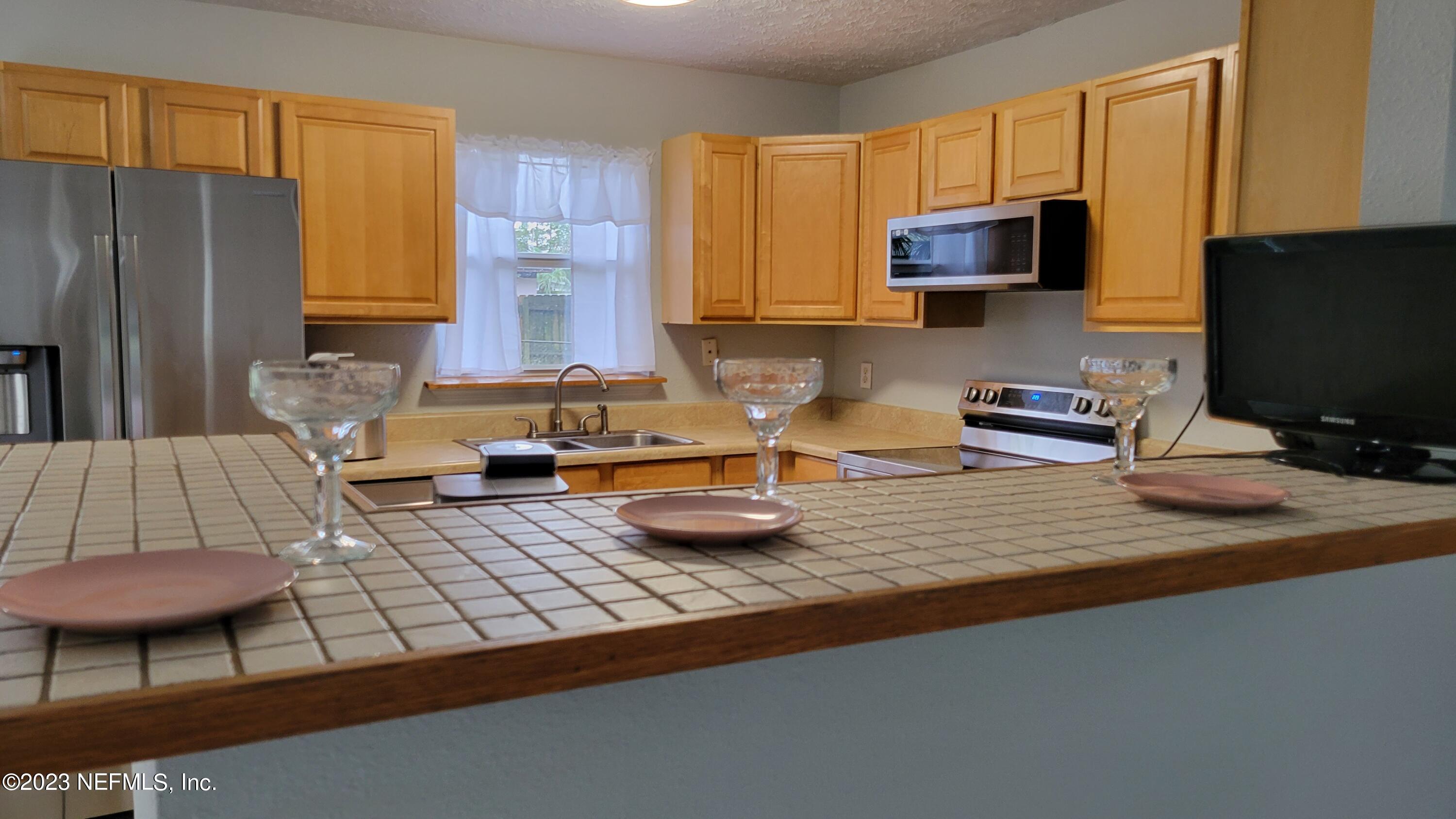 11685 Shellfish Drive Jacksonville, FL 32246 - Photo 10 of 32 a kitchen with a sink a stove and a microwave