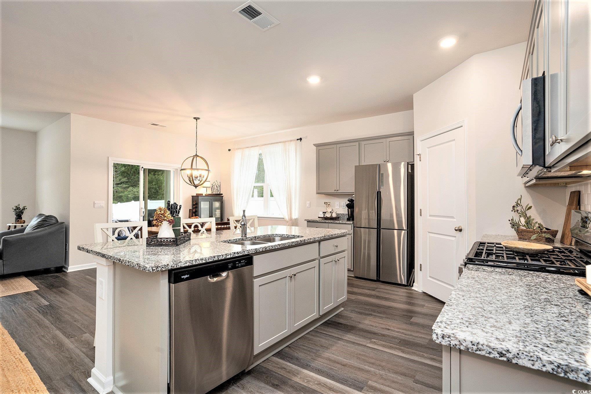 132 Columbus Street Conway, SC 29526 - Photo 12 of 39 Kitchen with appliances with stainless steel finishes, light stone countertops, dark wood-style flooring, gray cabinetry, and recessed lighting