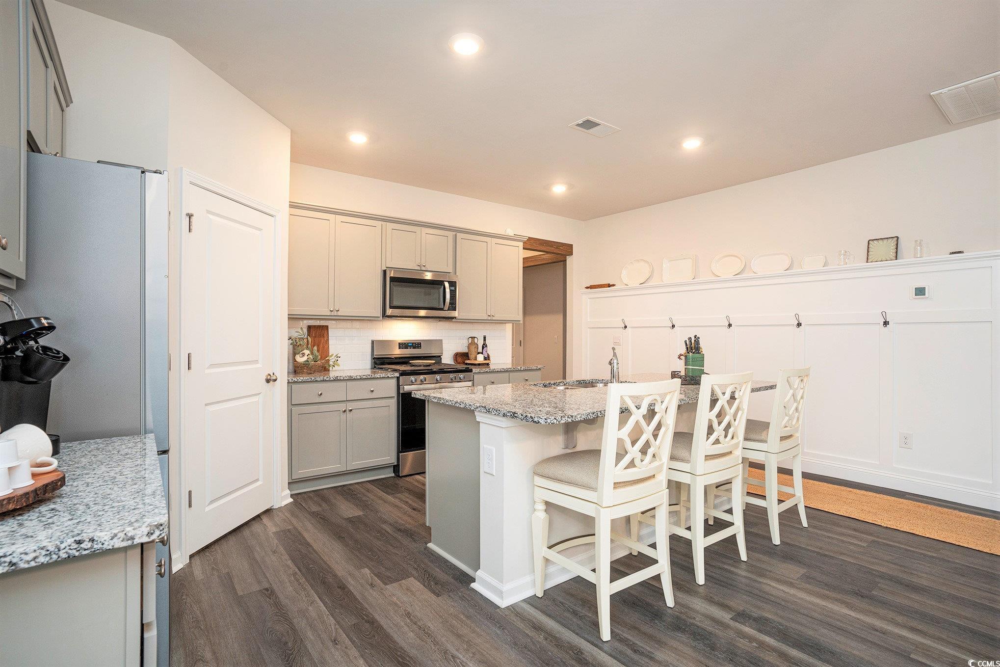 132 Columbus Street Conway, SC 29526 - Photo 16 of 39 Kitchen featuring gray cabinetry, appliances with stainless steel finishes, light stone counters, dark wood finished floors, and recessed lighting
