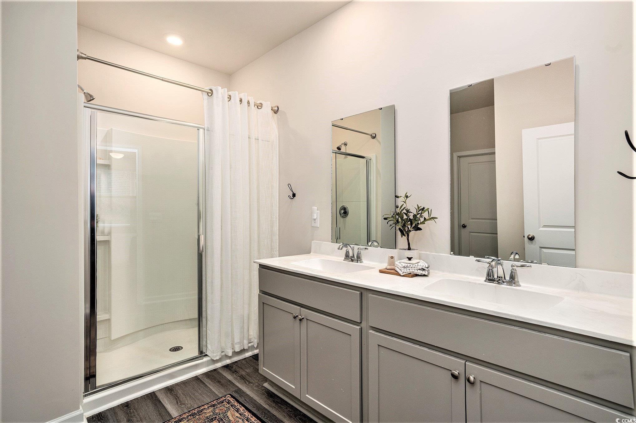 132 Columbus Street Conway, SC 29526 - Photo 23 of 39 Full bathroom featuring a shower stall, double vanity, and dark wood finished floors