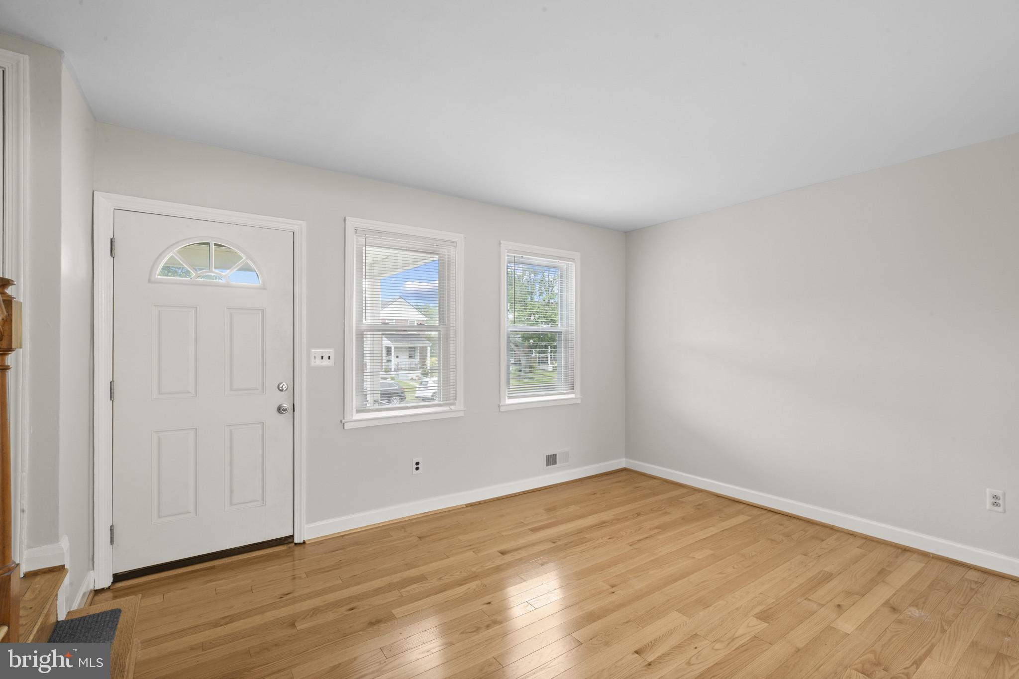 8343 Ridgely Oak Road Parkville, MD 21234 - Photo 5 of 31 an empty room with wooden floor and windows
