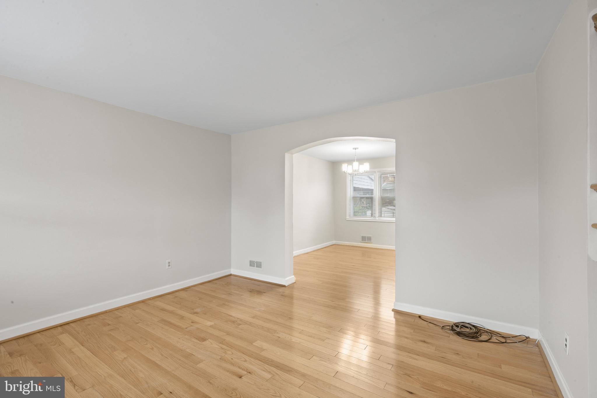 8343 Ridgely Oak Road Parkville, MD 21234 - Photo 6 of 31 a view of an empty room with wooden floor and a window