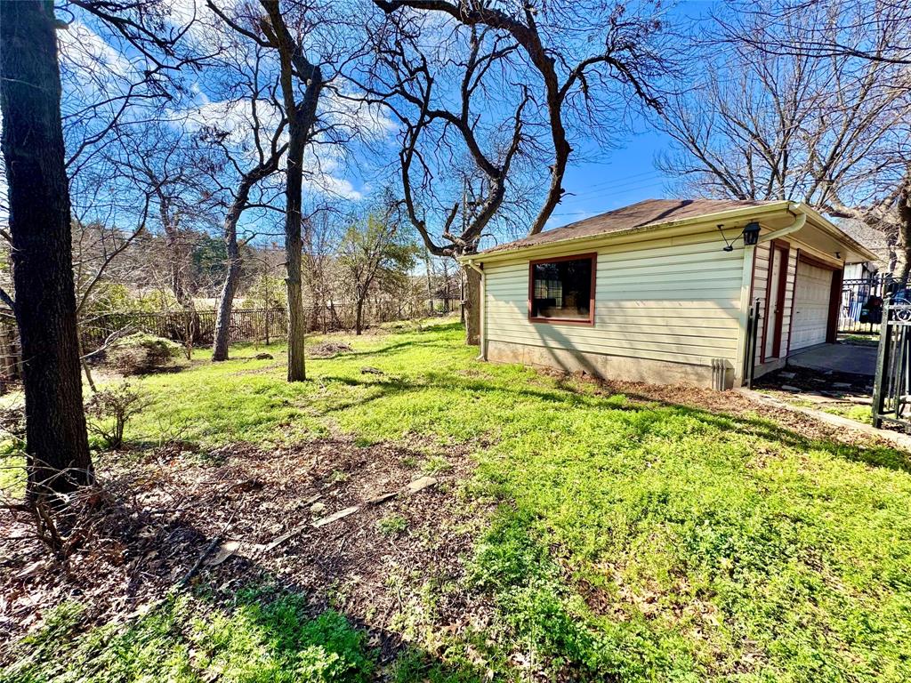 6712 Timothy Drive Dallas, TX 75227 - Photo 17 of 20 View of green lawn featuring a garage and an outdoor structure