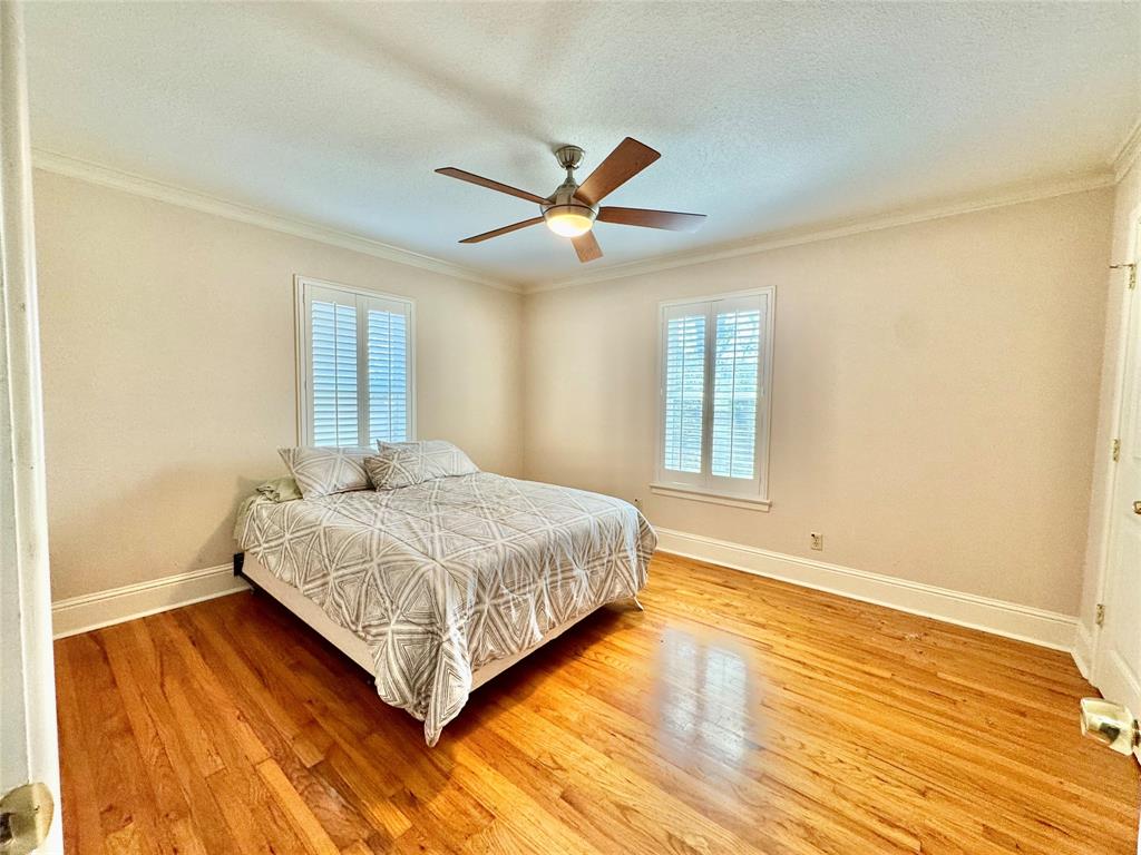 6712 Timothy Drive Dallas, TX 75227 - Photo 7 of 20 Bedroom featuring light wood-style floors, ceiling fan, a textured ceiling, and ornamental molding