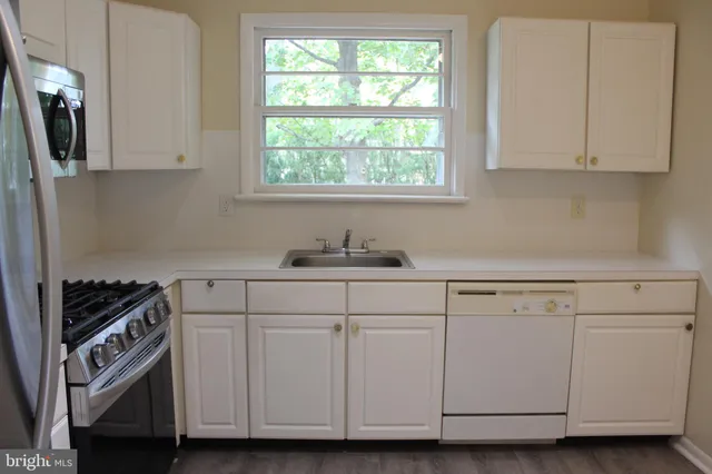 a kitchen with granite countertop white cabinets and white appliances