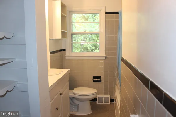 a bathroom with a toilet a sink and a window
