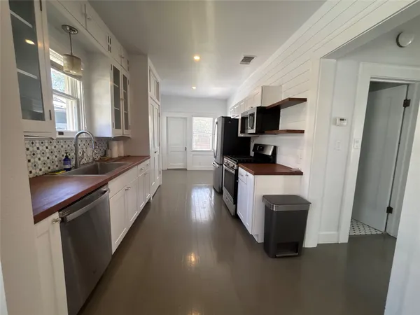 a bedroom with a bed and large windows