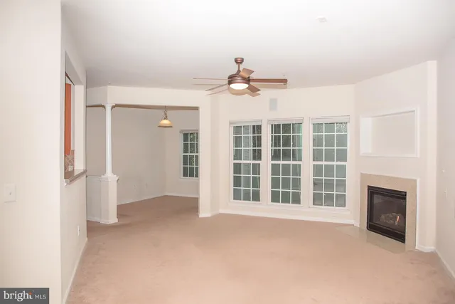 a view of an empty room with a fireplace and a window