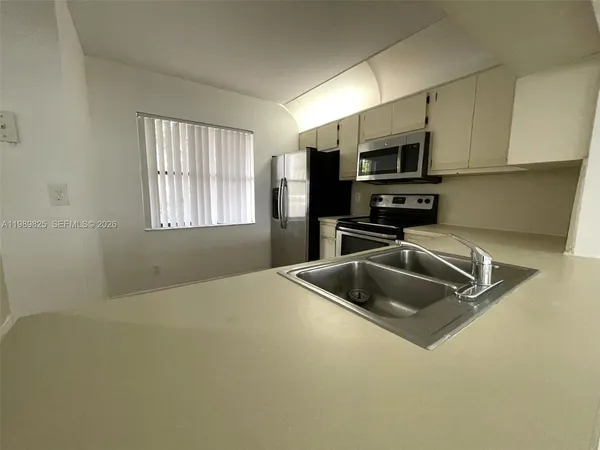 a kitchen with stainless steel appliances a sink a microwave a stove and refrigerator