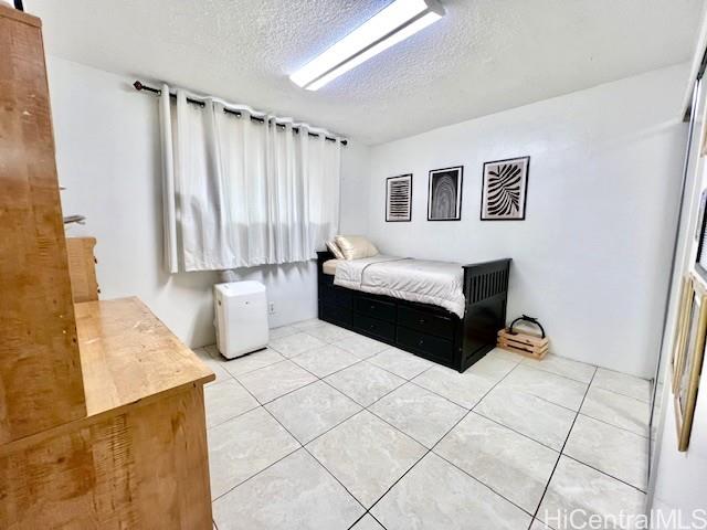 94-054 Leolua Street, Unit C114 Waipahu, HI 96797 - Photo 10 of 18 a spacious bedroom with a bed and a couch
