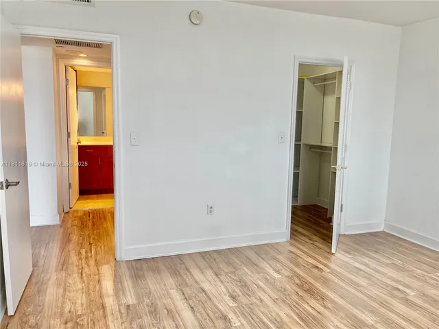 an empty room with wooden floor and closet