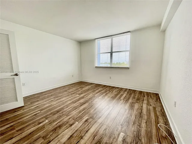 a view of a room with wooden floor and white walls