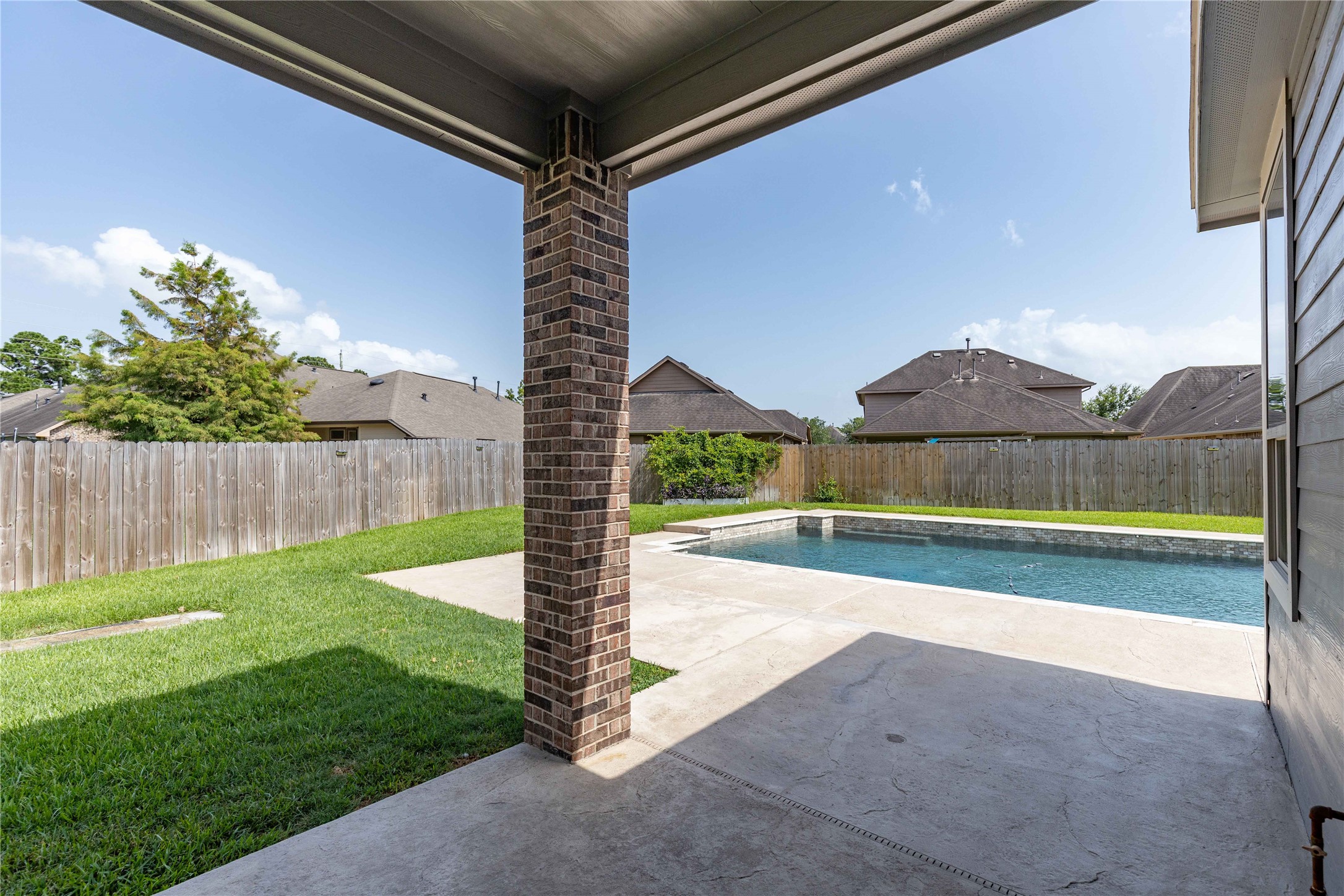 17206 Upper Ridge Lane Humble, TX 77346 - Photo 40 of 50 This backyard features a spacious covered patio overlooking a private, fenced-in yard with a well-maintained pool, perfect for outdoor relaxation and entertaining.