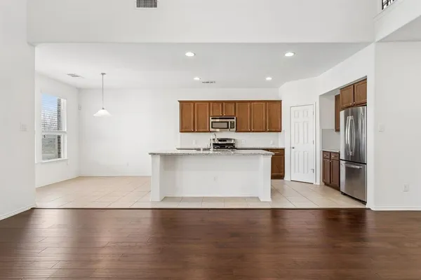 a view of kitchen with stainless steel appliances a refrigerator and wooden floor