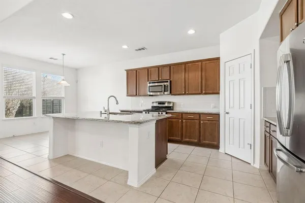 a kitchen with stainless steel appliances granite countertop a refrigerator and a sink