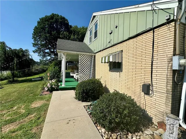 a backyard of a house with plants and tree